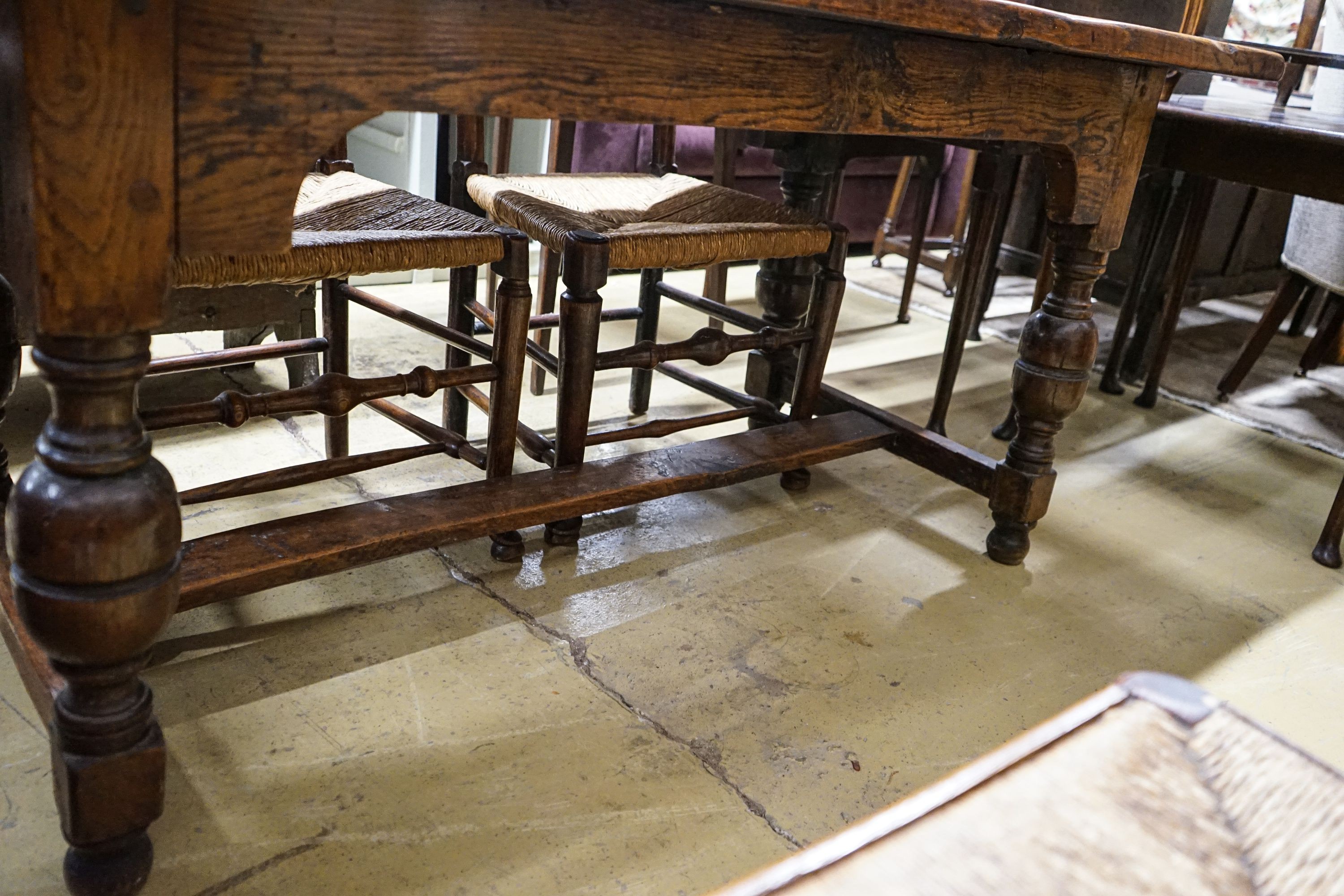 A 17th century style oak refectory table, with cup and cover legs and H stretcher, length 177, depth 74cm, height 77cm